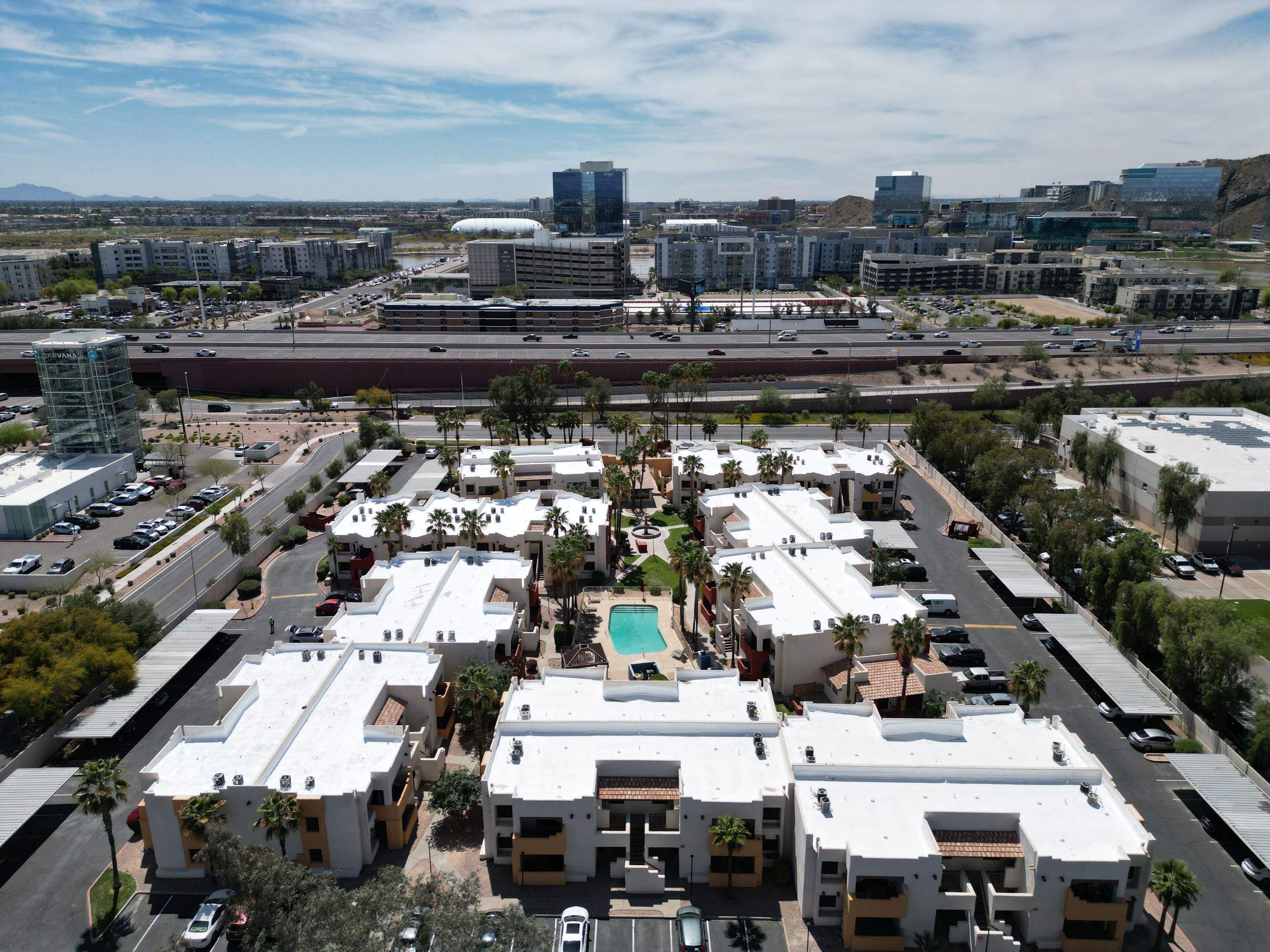 Aerial view of a Tempe multifamily roof with the Phoenix skyline behind